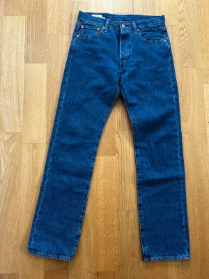 Mörkblå raka jeans - Säljer ett par klassiska mörkblå jeans med rak passform och fem fickor. Jeansen har normal midja och är tillverkade i kraftigt denimtyg. Perfekta för en avslappnad och tidlös stil.