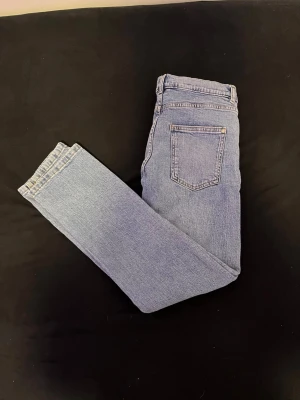 Ljusblå raka jeans - Säljer ett par ljusblå jeans med rak passform och klassisk femficksdesign. Jeansen har normal midja och är tillverkade i denim med en snygg tvätt. Perfekta till en avslappnad stil och passar till det mesta i garderoben.