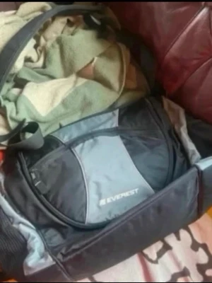 Svart och grå skötväska Everest - Rymlig skötväska i svart och grått från Everest. Väskan har flera fack, justerbar axelrem och bärhandtag. Perfekt för gymmet eller träning. Snygg och praktisk design med logga på sidan.liten fläck på byta börja delen 