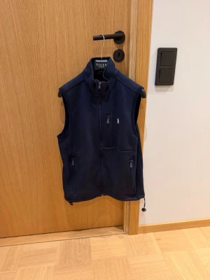 Mörkblå fleeceväst Ralph Lauren - Mörkblå fleeceväst från Ralph Lauren. Storleken är S. Använd i ca 1 år men är i mycket fint skick, dvs 8/10. Passar både inne och ute och för alla årstider.