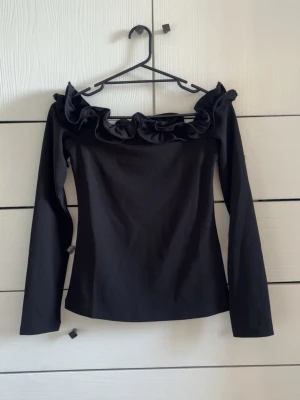 Off shoulder topp - Svart off shoulder topp med volang upptill