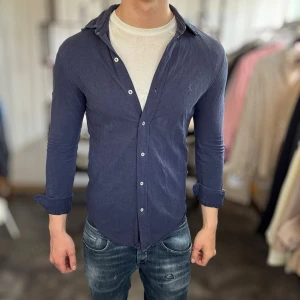 Slim fit Ralph lauren skjorta - Bra skick, lite urtvättad men inget allvarligt. Nypris ca 1500kr. Passar dig som är 170-180cm ungefär. Modellen är 185 cm, 75 kg. Alltid billigare pris vid köp av flera varor‼️🙌Svarar alltid på frågor eller funderingar! 