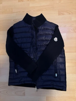 Moncler Cardigan - Snygg blå cardiganjacka från Moncler. Sitter jättebra och är i nyskick, använd ett fåtal gånger. NFC funkar.