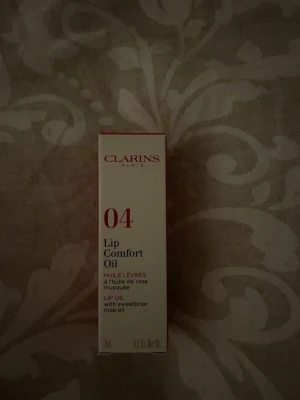 Clarins Lip Comfort Oil 04 Pitaya - Clarins Lip Comfort Oil i nyansen 04 Pitaya är ett läppbalsam i oljeform som ger glans och vård till läpparna.