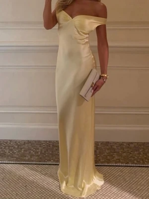 Ljusgul axelbandslös långklänning - Elegant ljusgul långklänning i glansigt material med offshoulder-design och figurnära passform. Klänningen har en vacker omlott-detalj vid bysten och faller mjukt längs kroppen. Perfekt för speciella tillfällen.          💛Klänningen är helt ny med prislapp. Nyspris runt 1000kr. Skriv för fler bilder, den passade inte mig💛