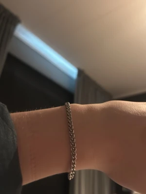 Silverfärgat kedjearmband - Stilrent armband i silverfärgad metall med klassisk kedjelänk. Perfekt för dig som gillar minimalistiska accessoarer med en tidlös känsla. Armbandet har en enkel och smidig låsning och passar till de flesta handledsstorlekar.