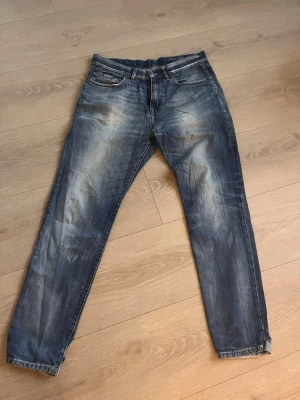 Blåa tapered jeans från Esprit - Säljer ett par blåa tapered jeans från Esprit med snyggt slitna detaljer och tvättad look. Modellen heter Slouch och har avsmalnande ben samt lite mer utrymme upptill. Klassisk femficksdesign och bekvämt denimtyg.