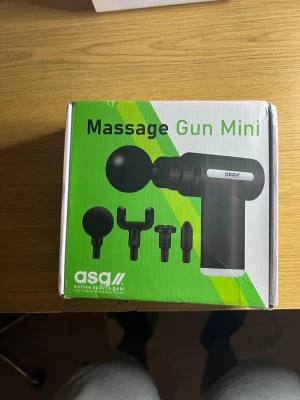 Massage Gun Mini från asg - Smidig Massage Gun Mini från asg med fyra olika massagehuvuden för varierad muskelbehandling. Kommer i svart plast och levereras i originalförpackning. Perfekt för återhämtning efter träning eller för att lindra spänningar.