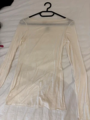 Intimissimi beige tröja! - Säljer en tunn och figurnära långärmad topp i ljusbeige mesh från intimissimi. Toppen är lätt transparent och har en enkel, stilren design med rund hals. Perfekt att styla lager på lager eller bära som den är för en clean look. Den är endast använd 2 gånger och är ännu lika gott som ny.
