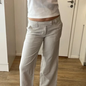 Vida beige linnebyxor - Snygga beige linnebyxor med raka, vida ben och klassisk midja. Byxorna har hällor för skärp, fickor fram och stängs med dragkedja och knapp. Köpt på Vinted men tyvärr för korta för mig (bild 6 är från förra ägaren). Innerbenslängden är ca 74cm