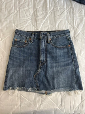 Jeanskjol från Levi's - Blå jeanskjol från Levi's, i nyskick, storlek 24. 