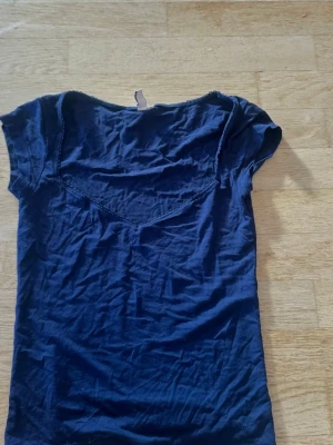 Mörkblå v-ringad topp - En enkel mörkblå topp med v-ringning och korta ärmar. Toppen har en smickrande passform och är tillverkad i ett mjukt material som känns bekvämt mot huden. Perfekt att matcha med jeans eller kjol för en avslappnad look.