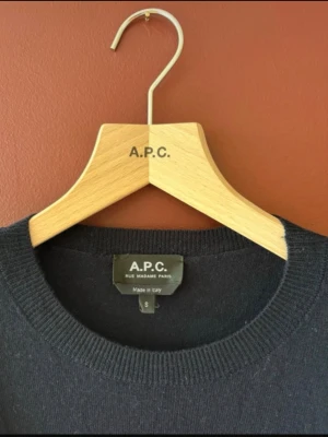 Mörk blå tröja från A.P.C. - Klassisk mörk  tröja från A.P.C. i enkel och stilren design. Tröjan har rund halsringning, långa ärmar och diskret broderad logga på bröstet. Perfekt basplagg för en clean look. Lite liten i storleken 