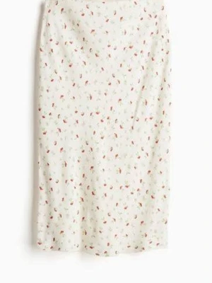 Vit blommig midikjol - Söt vit midikjol med små blommor i rosa och grönt. Kjolen har rak passform och faller mjukt längs benen. Perfekt för dig som gillar en romantisk och somrig stil. Tillverkad i ett lätt tyg som känns skönt mot huden.