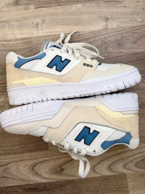 New Balance 550 beige/blå sneakers - Snygga New Balance 550 sneakers i beige och ljusblått med vita detaljer. Skorna har en låg siluett, mocka och mesh-paneler samt klassisk N-logga på sidan. Endast använda en gång tyvärr 