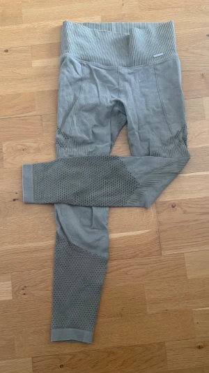 Gröna sömlösa leggings med mönster aim’n - Snygga gröna leggings med hög midja och ribbade detaljer. Sömlös design för extra komfort och mesh-liknande mönster på benen. Perfekta för träning eller chill. Materialet är stretchigt och följsamt för bästa passform.