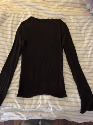Svart långärmad topp - En enkel och stilren svart långärmad topp med rund hals. Tunn och mjuk i materialet, perfekt att matcha med olika outfits. Passformen är normal och toppen är utan synliga detaljer eller mönster. Lappen är tyvärr avklippt men den är ifrån bikbok. 