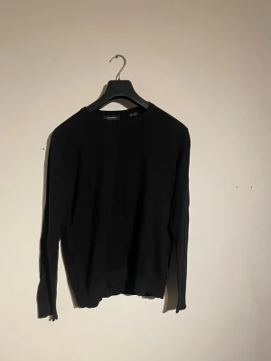 Svart stickad tröja - En enkel och stilren svart stickad tröja från Jack n Jones med rund hals och långa ärmar. Perfekt basplagg att matcha med olika outfits. Tröjan har en klassisk passform och är mjuk och bekväm. Nypris 800kr