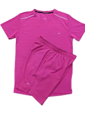 Rosa träningsset med t-shirt och shorts - Säljer ett sportigt träningsset i stark rosa färg, består av en kortärmad t-shirt och matchande shorts. Setet har diskreta vita detaljer och är gjort i ett lätt, snabbtorkande material som passar perfekt för löpning eller gym.