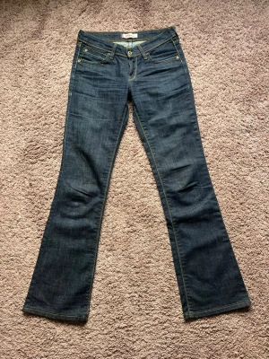 Levis 572 bootcut lowwaist lågmidjad, 00s vintage - Levis jeans i den utgångna modellen 572 bootcut. Modellen är 00s superlågmidjad och utsvängd i benen. Superfint skick och har själv inte hittat några skavanker på dem, tyvärr aldrig använts av mig eftersom de är för långa. Storlek: W29 L34  Midjemått: 38cm Innerbenslängd: 85cm Grenhöjd: 20cm Benvidd: 24cm