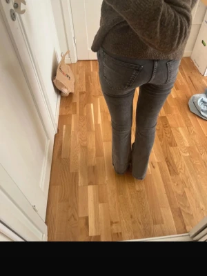 Grå bootcut jeans med låg midja Gina tricot - Säljer ett par gråa bootcut jeans med låg/mellan midja. Jeansen har en snygg tvätt och sitter tight över låren för att sedan bli vidare nedtill. Lite korta för mig som är 173