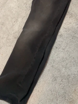 Svarta slim fit jeans - Säljer ett par svarta slim fit jeans med lätt tvättade detaljer på låren. Jeansen har klassisk femficksdesign och raka ben. Perfekta till en avslappnad och stilren look.