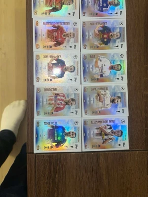 Fotbollskort  - Säljer en samling glittriga fotbollskort med kända spelare från Champions League. Kort i färger som röd, blå, vit och gul med holografisk effekt. Spelare som Xavi, Schweinsteiger, Raúl och Del Piero finns med. Perfekt för dig som gillar fotboll och samlarkort.
