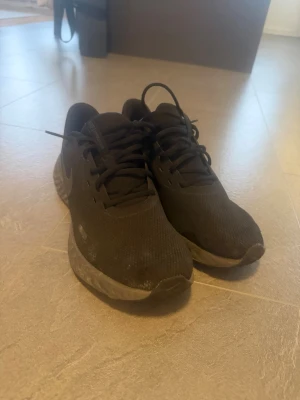 Svarta Nike sneakers  - Säljer ett par helsvarta Nike sneakers  Skorna har snörning och en bekväm, dämpad sula som passar perfekt för vardagsbruk. Stilren design som funkar till det mesta.