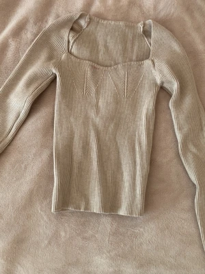 Beige ribbad top - säljer beige ribbad topp från SHEIN💕 storlek XS som sitter tight🪷 finns dock en fläck som går bort i tvätten annars finns inga defekter💌