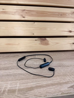 Sony WI-C200 trådlösa in-ear hörlurar - Sony WI-C200 trådlösa in-ear hörlurar med nackband. Har inbyggd kontroll på sladden för volym och styrning.   Passar i synnerhet bra till träning då risken för att tappa dem är minimal jämfört med true wireless hörlurar.   Bra ljud, fungerar som de ska. Medföljer laddare (USB-C).