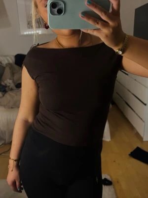 Mörkbrun off shoulder body - Säljer en  mörkbrun body med off shoulder-skärning och korta ärmar. Bodyn är köpt från pull&bear och är ej andvänd ( prislapp kvar)  storlek S och köpt för 200kr. Skriv privat för frågor eller fler bilder!!❤️