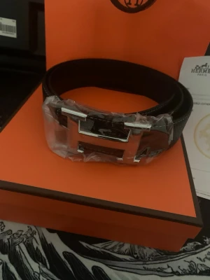 Svart H skärp med silverdetalj - Snyggt svart skärp från H med ikoniskt H-spänne i silverfärgad metall. Skärpet är stilrent och passar perfekt till jeans eller kostymbyxor. Levereras med originalförpackning och tillbehör.