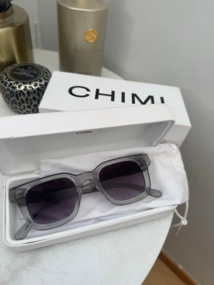Grå CHIMI solglasögon - Snygga solglasögon från CHIMI med transparent grå båge. Kommer med med original box o är knappt använda. 04