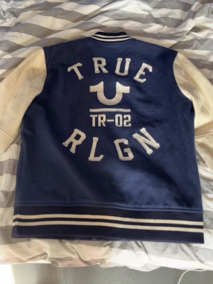 True Religion jacka - True Religion varsity jacka från 2002. Inte så lätt att hitta sånna. Riktigt bra skick. Skickar direkt. Storleken är XL fast passar L. 