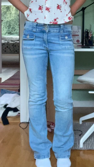 Ljusblå bootcut jeans - Säljer ett par ljusblå jeans i mycket bra skick då de inte använts så mycket. Det är justerbar midja och de har snygga fickor där fram. De är väldigt sköna att ha på sig eftersom materialet är stretchigt. Storleken är 164.