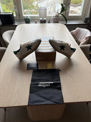 Golden goose ballstars sneakers  - Snygga vita sneakers från golden goose med gröna detaljer och en grön stjärna på sidan. Skorna har beige snörning, grön hälkappa. Medföljer originalkartong, certifikat och dustbag. Perfekta för dig som gillar en sportig och trendig look.
