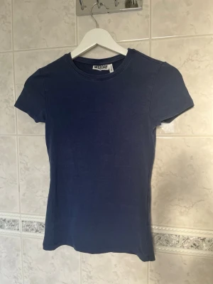 Mörkblå t-shirt från Weekday - En enkel och stilren mörkblå t-shirt från Weekday. Modellen är klassisk med rund halsringning och korta ärmar. Tillverkad i mjuk material, perfekt basplagg att matcha till allt💕