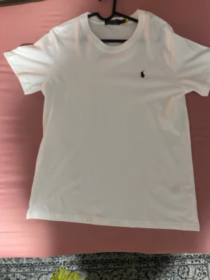 Vit ralph lauren t-shirt - Polo-tröja – Vit  Vit Polo-tröja i fint skick 🤍 Endast använd 1 gång, så den är i princip som ny. Inga fläckar eller skador.  📦 Skickas snabbt och välpackad! 💬 Hör av dig vid frågor.