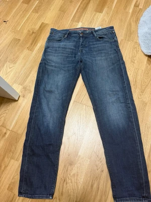 Mörkblå raka jeans - Snygga mörkblå jeans med raka ben och klassisk femficksmodell. Jeansen har subtila slitningar och kontrastsömmar, samt detaljerade bakfickor. Tillverkade i denim som ger en skön och avslappnad look.