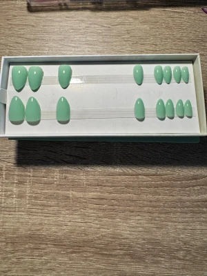 Switch Nails Matcha Doin Almond Short - Press-on naglar i modellen Matcha Doin från Switch Nails. Naglarna har en kort mandelform och kommer i en snygg matchagrön färg. Tillverkade av återvunnet material och kan återanvändas. Perfekt för dig som vill ha salongskänsla hemma. Säljes utan tillbehör.
