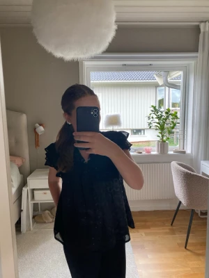 Svart blus med volang från Gina Tricot - Svart glittrig blus från gina tricot till t.e.x nyår