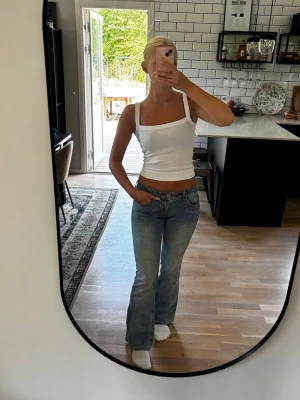 Blå bootcut jeans med låg midja - Säljer ett par blå bootcut jeans med låg midja från J.Galt. Vid köp var byxorna för stora och  sydde därför in dom i midjan med resårband (se bild). Det är lätt att ta bort om man inte vill ha kvar det. Jag är 163 cm. Publicerad på flera säljsidor 🌸