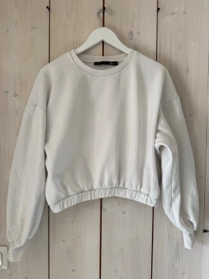 Vit sweatshirt från 157 - En stilren vit sweatshirt från 157 i storlek M. Tröjan har rund halsringning, långa ärmar och resår i midjan för en snygg passform. Tillverkad i mjukt och bekvämt material.