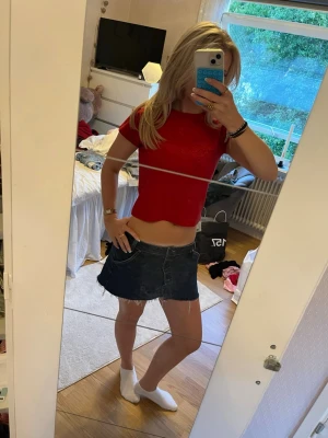 Röd glittrig crop top - Snygg röd crop top med glittrigt tyg och korta ärmar. Toppen har en rund halsringning och är figurnära i modellen, perfekt att styla med jeans eller kjol. Materialet är stretchigt och ger en bekväm passform.