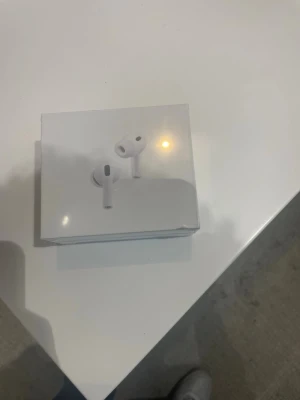 Vita trådlösa hörlurar - Säljer ett par vita trådlösa in-ear hörlurar med stilren design och kompakt laddningsetui. Hörlurarna har en modern look och passar perfekt för musik, poddar och samtal. Levereras i originalförpackning.