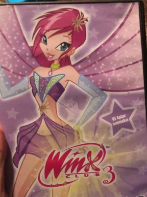 Winx Club 3 DVD på svenska - DVD med Winx Club säsong 3, omslaget är lila med motiv av tecknade karaktärer från serien. Innehåller fyra avsnitt: Trollkarlens Utmaning, Häxornas Avslöjande, Trollkarlens Vrede och En Ny Början. Text och tal på svenska. Plastfodral med färgglad design.