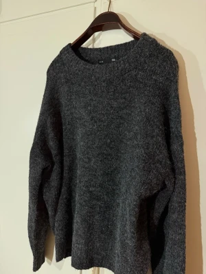 Mörkgrå stickad tröja - Mysig och oversized stickad tröja i mörkgrått. Tröjan har rund halsringning och långa ärmar. Perfekt mys tröja till hösten och snygg till ett par jeans eller leggings. Nästan helt oanvänd. 