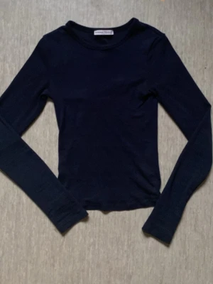 Mörkblå långärmad topp  - En enkel och stilren mörkblå långärmad topp från Bershka. Modellen är tight och har rund halsringning. Perfekt att matcha med jeans eller kjol för en clean look.