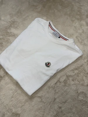 Vit Moncler t-shirt - Säljer en sprillans ny moncler T-shirt, den har ej något tecken på användning. T-shirten köptes för länge sedan men har ej använt den en ända gång. Kom gärna privat för mer information eller bilder på tröjan😊