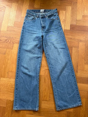 Blå raka jeans från 157 - Snygga blå jeans från 157 med rak passform och klassisk femficksdesign. Jeansen har hög midja och är tillverkade i ett robust denimtyg. Perfekta för en avslappnad och trendig stil.